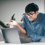 Picture of a clueless man sitting in front of a laptop