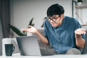 Picture of a clueless man sitting in front of a laptop